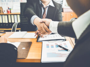 Businessman and lawyers handshake after meeting, financial contract deals and problematic business deals with government organizations.