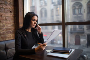 Female proud candidate reading summary during cellphone conversation